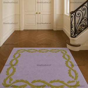 Könnte beinhalten: Ein rechteckiger, lavendelfarbener Teppich mit einem grünen Blätterbordürenmuster. Der Teppich liegt in einem Flur mit weißen Wänden, Holzboden und einer Treppe mit einem schwarzen schmiedeeisernen Geländer. Der Text "SineStudioLLC" ist sichtbar.
