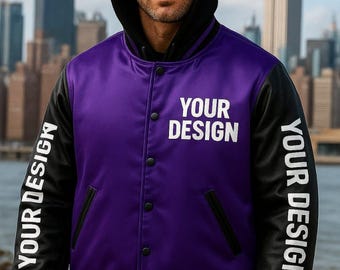 May include: A purple and black varsity jacket with the text "YOUR DESIGN" on the sleeves and "YOUR DESIGN" on the chest. The jacket has a black hood and black ribbed cuffs. The background features a cityscape.