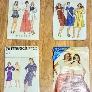 May include: Four vintage sewing pattern packets from Butterick and See & Sew. The packets feature illustrations of women's clothing designs, including dresses, skirts, and tops. The packets are on a wooden surface.