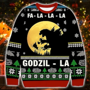 Può includere: Maglione natalizio nero con una silhouette di Godzilla davanti a una luna piena. Il maglione presenta le scritte "FA-LA-LA-LA" e "GODZIL-LA" con fiocchi di neve, alberi e altri motivi festivi.