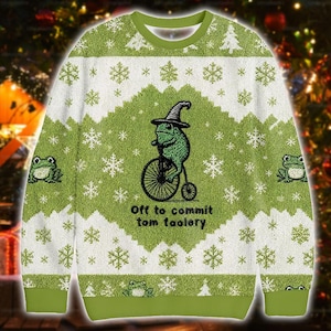May include: Green and white Christmas jumper with a frog on a unicycle, wearing a hat, and the text "Off to commit tom foolery." The jumper features snowflakes and frog designs.