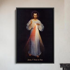 May include: Framed artwork depicting a religious figure with a halo, wearing a white robe, and radiating light. The text "Jesus, I Trust in You" is at the bottom. The artwork is displayed above a wooden chair and a fireplace.