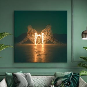 May include: A large square canvas art print depicting two wireframe figures holding hands, with a bright light in the center. The artwork is displayed above a sofa in a room with green walls and plants.
