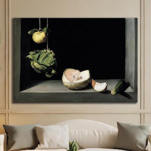 May include: A living room scene featuring a large framed artwork with a still life of fruit. The artwork is above a white sofa with gray pillows. A round wooden coffee table and two armchairs complete the space. The room has a neutral color palette.