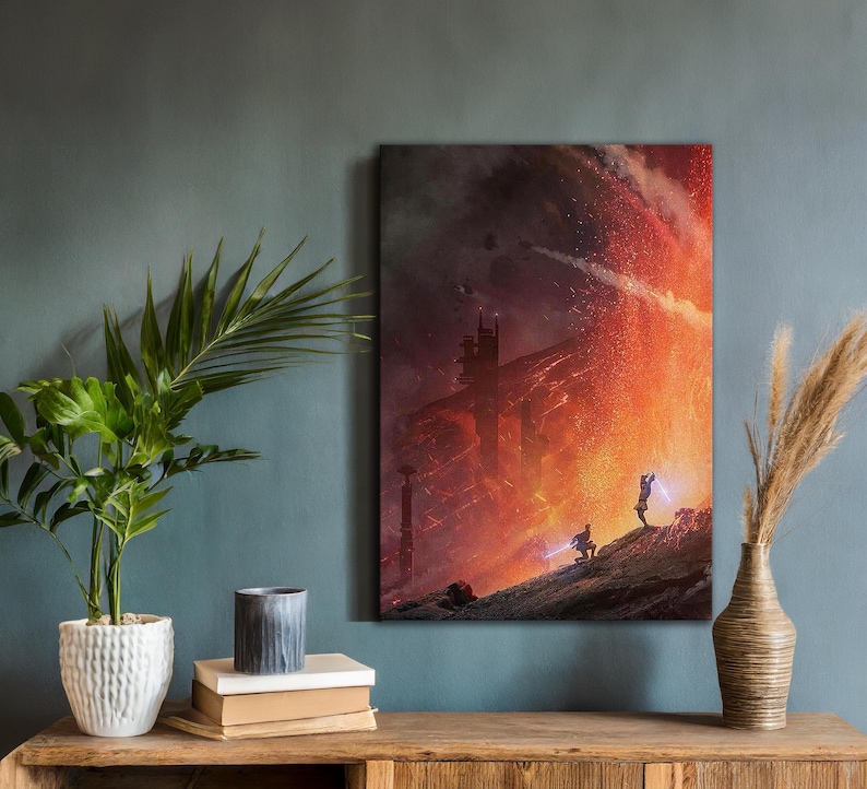 May include: A canvas print depicting a dramatic sci-fi scene with a fiery, orange and red background. Two figures stand on a rocky surface, facing a large structure. The artwork is displayed on a teal wall, with a plant and vase in the foreground.