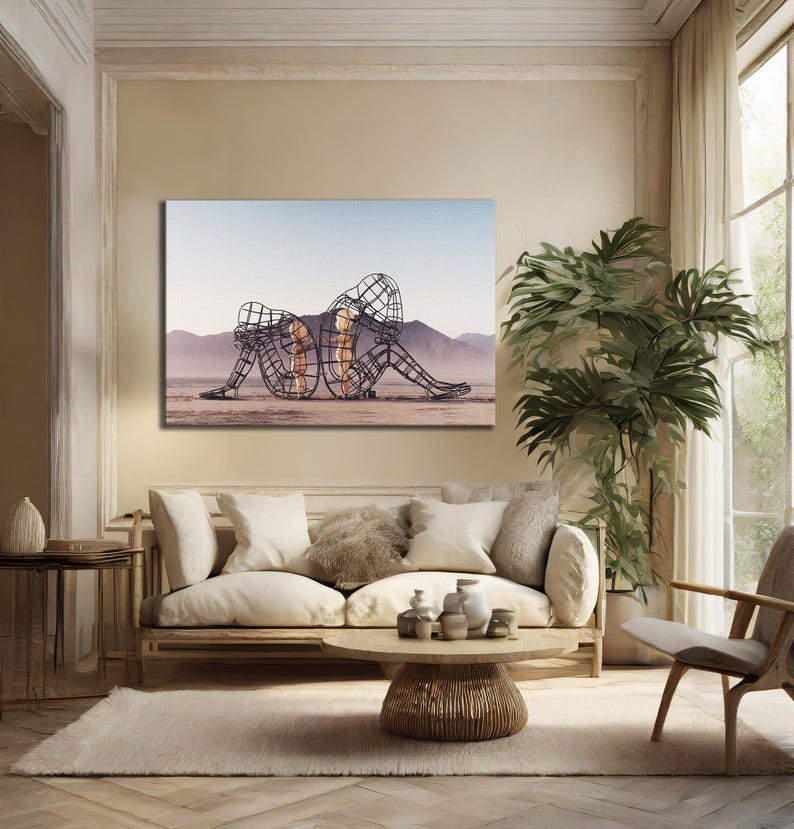May include: A canvas print featuring a wireframe sculpture of two figures embracing. The sculpture is set against a desert landscape with mountains and a blue sky. The figures are filled with a warm, golden light.
