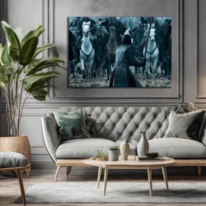 May include: A large canvas print depicting a battle scene with riders on horseback. The artwork is mounted above a gray tufted sofa with wooden legs. A large potted plant and decorative items complete the room's decor.