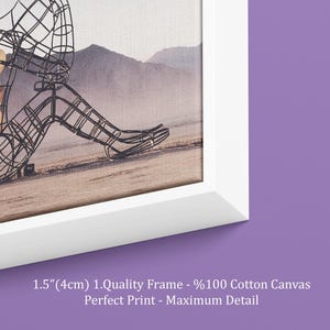 May include: White framed canvas art print featuring a wireframe sculpture of a person sitting on a beach. The background shows mountains and a hazy sky. The frame is 1.5 inches (4cm) thick. The text on the frame says "Perfect Print - Maximum Detail."