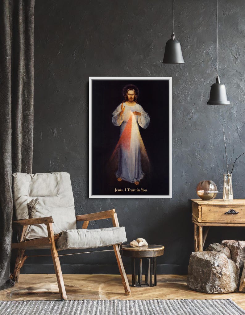 May include: A framed print of a religious figure with a halo, wearing white and light blue robes, with red and white light emanating from the chest. The text "Jesus, I Trust in You" is at the bottom.