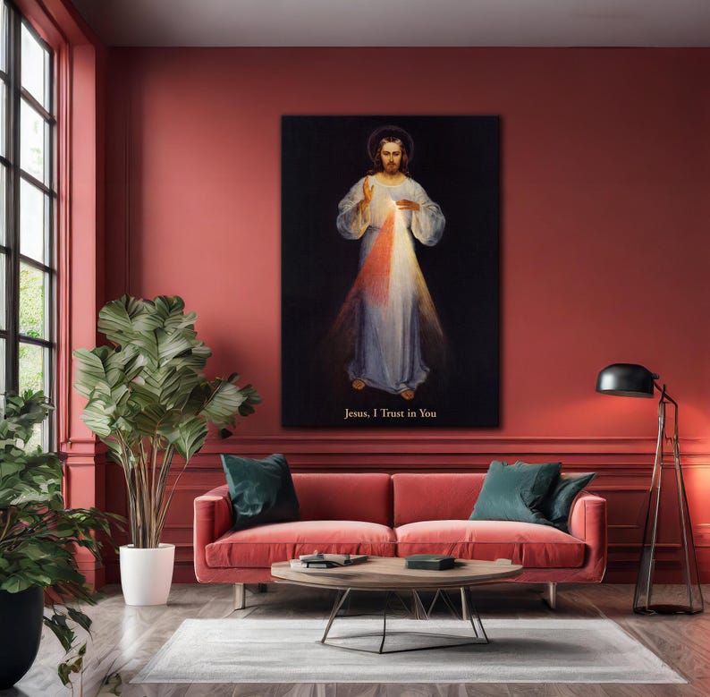 May include: A framed religious artwork depicting Jesus with light emanating from his chest. The artwork is set against a black background and features the text "Jesus, I Trust in You". The image is displayed in a living room setting.
