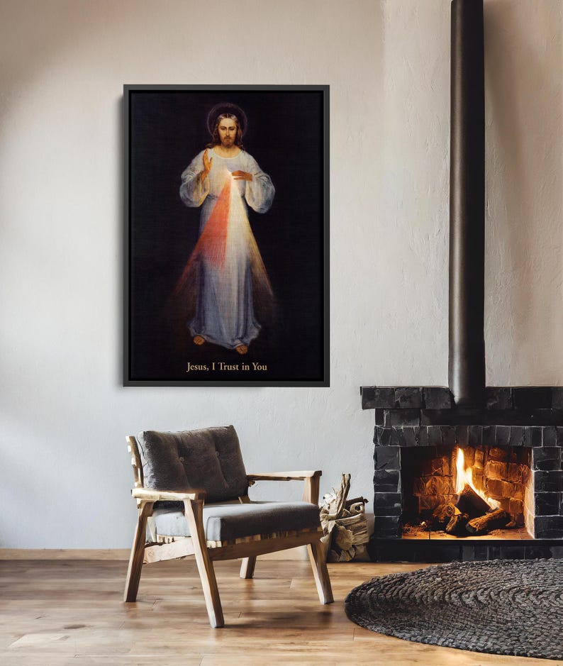 May include: Framed artwork depicting a religious figure with a halo, wearing a white robe, and radiating light. The text "Jesus, I Trust in You" is at the bottom. The artwork is displayed above a wooden chair and a fireplace.