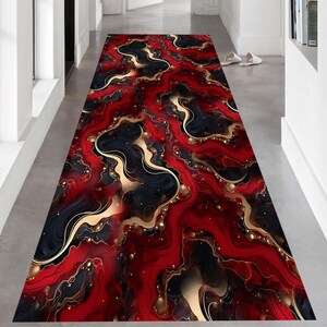 May include: A long, rectangular rug with a striking abstract design. The rug features a flowing pattern of red, black, and gold, creating a marbled effect. The design includes swirling lines and gold accents, adding a touch of luxury. This rug is suitable for hallways and entryways.