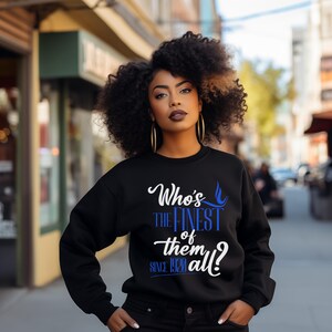 May include: A black long-sleeve sweatshirt featuring white and blue text that reads Who's THE FINEST of them all? SINCE 1920. The garment has a crew neckline and ribbed cuffs, providing a standard fit with a graphic design printed on the front chest.