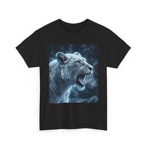 May include: Black t-shirt featuring a detailed, blue-toned image of a roaring lioness. The lioness is depicted with open mouth and visible teeth, set against a dark, atmospheric background. The shirt is a classic crew neck style.