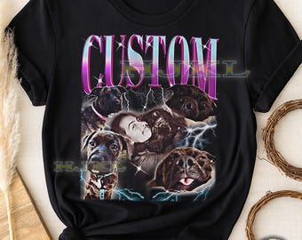 May include: Black adult unisex t-shirt with a graphic design. The design features the word "CUSTOM" in a purple and pink gradient font, images of dogs, a person, and lightning bolt accents.