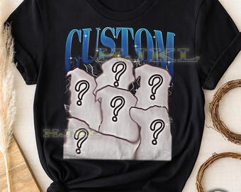 Può includere: T-shirt unisex nera per adulti con un design grafico. Il design presenta la parola "CUSTOM" in blu e bianco, con un effetto fulmine. Sotto, sei forme bianche con punti interrogativi.