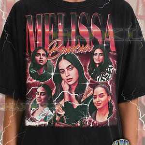 May include: Black adult unisex t-shirt featuring a graphic of Melissa Barrera with her name in a retro style. The design includes multiple images of the actress with a lightning bolt effect. The shirt has the text "ADULT Unisex Shirt : BLACK".