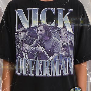 May include: Black adult unisex t-shirt with a graphic of Nick Offerman and other men. The word "NICK" is at the top, and "OFFERMAN" is at the bottom. The shirt also has the text "ADULT Unisex Shirt : BLACK".