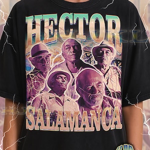 Könnte beinhalten: Schwarzes Unisex-T-Shirt für Erwachsene mit einem Vintage-Grafikdesign von fünf Männern und dem Text "HECTOR SALAMANCA". Das Design verwendet lila und türkis Farben.