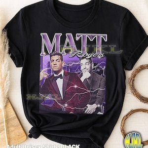 May include: Black adult unisex t-shirt featuring a vintage-style graphic of Matt Rogers. The graphic includes two images of Rogers, the name "MATT" in large, stylized letters, and the text "Rogers". The shirt has a crew neck and short sleeves.