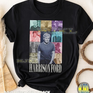 May include: Black adult unisex t-shirt featuring a collage of images of Harrison Ford. The design includes a central image of Ford and several smaller images around it. The name "HARRISON FORD" is printed in white below the images.