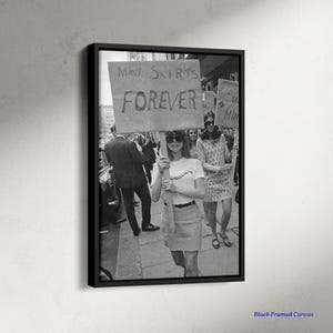 Puede incluir: Impresión en lienzo en blanco y negro enmarcada que representa una escena de protesta. Una persona sostiene un cartel que dice "¡Mini faldas para siempre!". Hay otras personas en el fondo. La persona lleva una camiseta y gafas de sol.