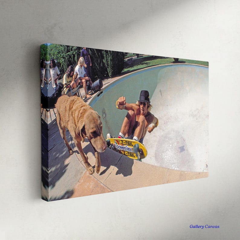 May include: Canvas print featuring a vintage skateboarding scene. A skateboarder in a black hat rides a yellow skateboard in a pool, with a dog nearby. Spectators watch from the edge of the pool. The image has a retro aesthetic.