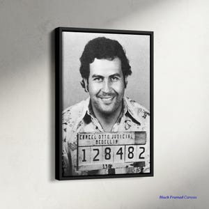 Puede incluir: Impresión en lienzo enmarcada en blanco y negro de un hombre sonriendo. El hombre lleva una camisa con cuello y tiene una placa de identificación con el texto "CARCEL OTTO JUDICIAL MEDELLIN" y el número "128482".