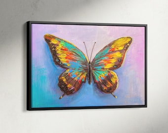 May include: A framed canvas print featuring a colorful butterfly. The butterfly has wings in shades of blue, yellow, orange, and brown. The background is a blend of blue, purple, and pink. The frame is black. Text on the bottom right says "Black Framed Canvas".