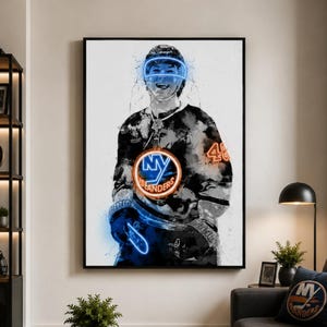 May include: A framed wall art print featuring a stylized black and white watercolor portrait of an ice hockey player wearing a jersey with the New York Islanders logo in orange and blue, accented with glowing neon blue light effects.