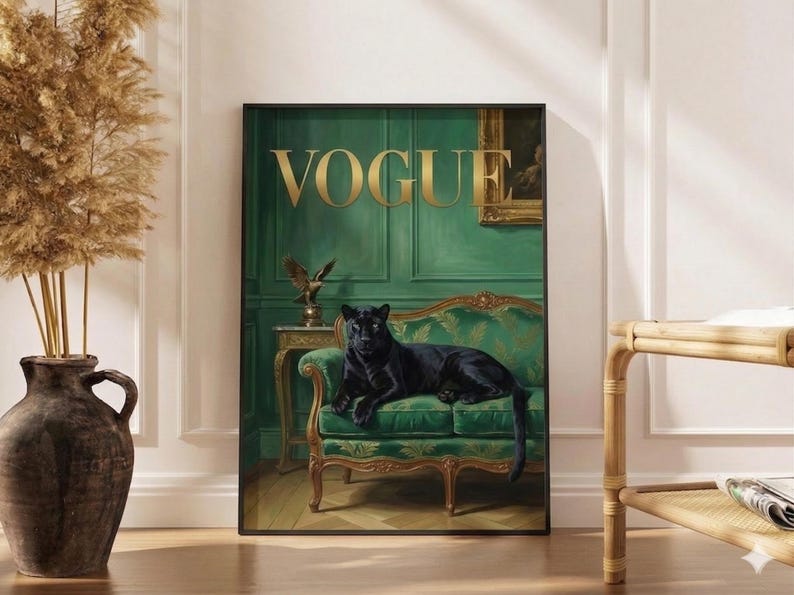 A framed poster of a black panther sitting on a green couch, with the word "Vogue" written on the poster. The poster is displayed on a wall, and there is a vase and a wooden table nearby.