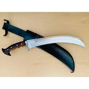 May include: A large, curved blade knife with a wooden handle and a black leather sheath. The blade is silver and the handle is dark brown with a textured grip. The sheath is black and has a belt loop.
