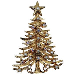 May include: Gold-toned Christmas tree brooch with a star on top. The brooch is adorned with faux pearls and iridescent rhinestones. The tree's branches are detailed with a textured finish, creating a festive and elegant accessory.