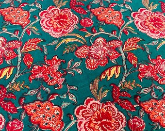 May include: A teal fabric with a repeating floral pattern. Large red and orange flowers with white accents are interspersed with smaller red buds and leaves. The design has a hand-painted appearance.