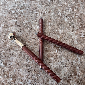 Puede incluir: Tres bastones de madera con acabado marrón oscuro. Un bastón tiene un mango de bola plateado. Dos varillas tienen un diseño de cuerda trenzada. Los bastones se exhiben sobre una superficie con vetas de mármol marrón y beige.