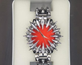 Reloj Casio personalizado con pinchos: estilo gótico punk, esfera roja y diseño llamativo.