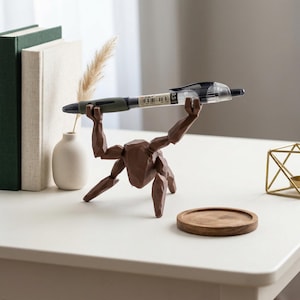 May include: A white ceramic mug with a black handle and the text "But First, Coffee" in a bold, black font. The mug is set against a blurred background, suggesting a cozy setting.