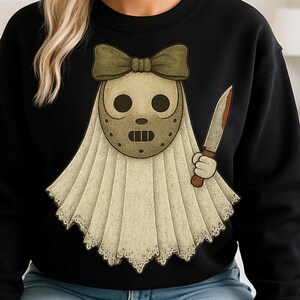 May include: Black sweatshirt featuring a cartoon ghost wearing a hockey mask and holding a bloody knife. The ghost has a tan bow and a white sheet with a lace trim. The design is a humorous take on a horror theme.