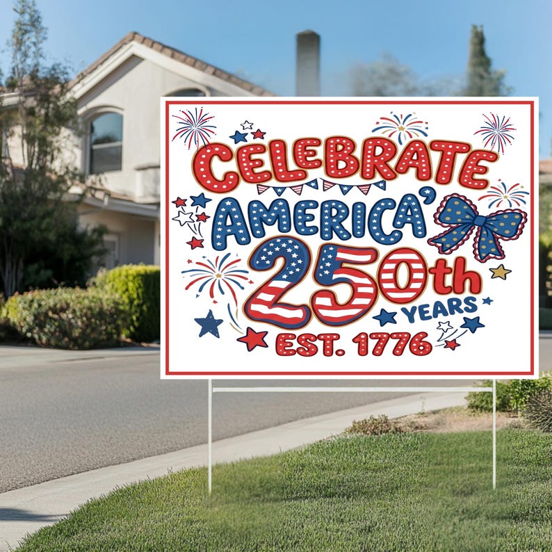 May include: A white sign with the text "Celebrate America's 250th Years Est. 1776" in red, white, and blue. The sign is decorated with stars, fireworks, and a bow. It is displayed on a lawn with a house in the background.