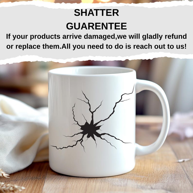 K&ouml;nnte beinhalten: Wei&szlig;e Keramik-Tasse mit schwarzem Shatter-Design. Die Tasse hat einen gebogenen Henkel und der Text "SHATTER GUARENTEE" ist dar&uuml;ber gedruckt. Die Tasse steht auf einer Holzoberfl&auml;che.
