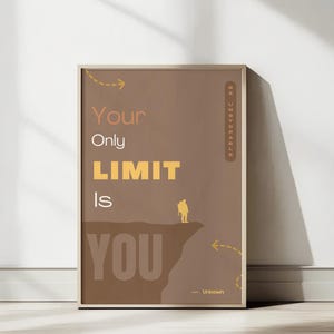 Könnte beinhalten: Gerahmtes Poster mit dem Text "Your Only LIMIT Is YOU" in Braun und Gelb. Eine kleine Illustration einer Person, die auf einer Klippe steht, ist enthalten. Das Poster lehnt an einer weißen Wand, mit Sonnenlicht und Schatten.