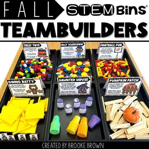 May include: A display of Fall STEM Bins TeamBuilders, featuring various activity sets. The sets include colourful blocks, shapes, and other materials for building and design projects. Each set has a theme, such as a haunted house or pumpkin patch.