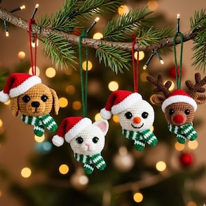 Può includere: Addobbi natalizi all'uncinetto a forma di cane, gatto, pupazzo di neve e renna. Ogni ornamento indossa un cappello da Babbo Natale e una sciarpa a righe verdi e bianche. Appesi a un ramo di pino.