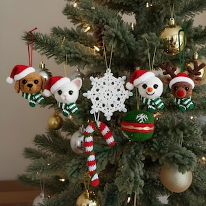 May include: A decorated Christmas tree featuring handmade crochet ornaments. The ornaments include a dog, cat, snowman, and reindeer, each wearing a Santa hat and scarf. Other ornaments include a snowflake, a candy cane, and a green and red ball.
