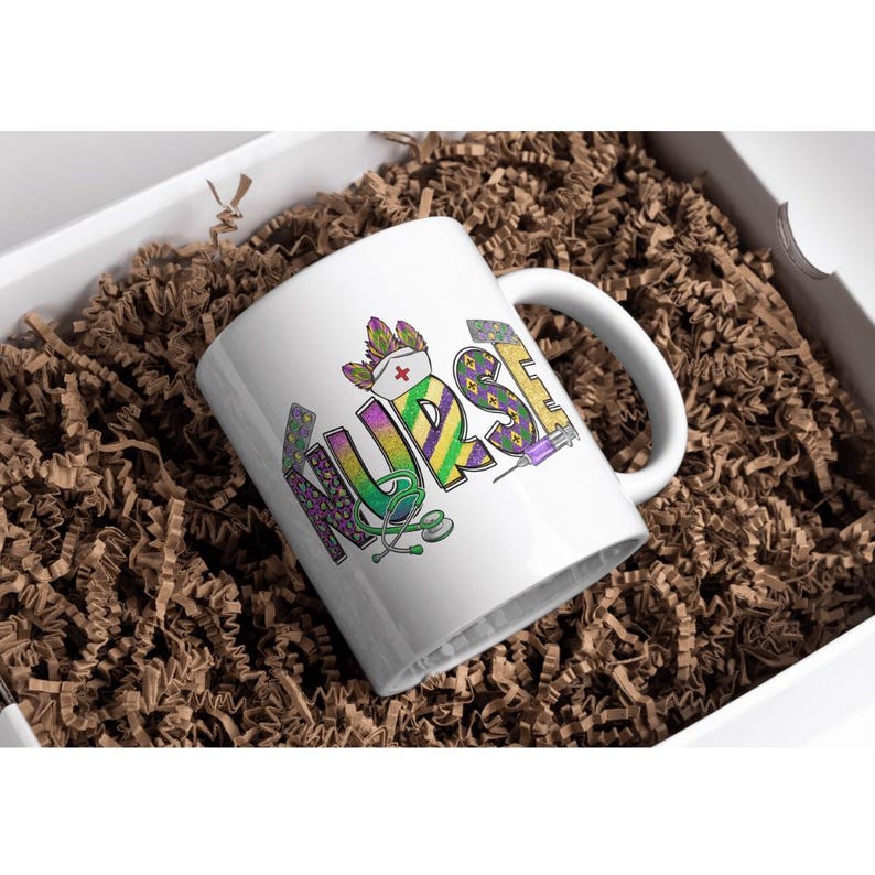 May include: White ceramic mug with the word "NURSE" in colorful, decorative lettering. The design includes a nurse's hat, stethoscope, and syringe. The mug is presented in a white box filled with brown crinkle paper.