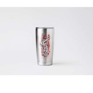 May include: A stainless steel tumbler with a silver lid. The tumbler features a graphic of a person doing a handstand, with red hearts and accents. The person is wearing a white shirt, gray pants, and red shoes.