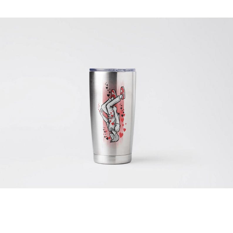 May include: A stainless steel tumbler with a silver lid. The tumbler features a graphic of a person doing a handstand, with red hearts and accents. The person is wearing a white shirt, gray pants, and red shoes.