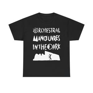 Może przedstawiać: Czarny t-shirt z białym napisem "Orchestral Manoeuvres In The Dark" w stylizowanej czcionce. Projekt zawiera słońce, trójkąty i twarz. Klasyczny t-shirt dla fanów muzyki.
