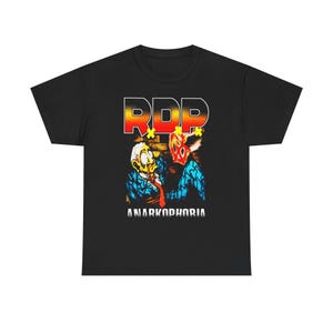 Könnte beinhalten: Schwarzes T-Shirt mit einem grafischen Design. Das Design enthält den Text "RDP" in Gelb und Orange und das Wort "ANARKODPHORIA" in Weiß. Die Grafik zeigt zwei Figuren in Blau und Rot.