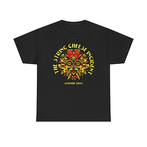 Puede incluir: Camiseta negra con un diseño gráfico colorido. El diseño presenta el texto "THE STRING CHEESE INCIDENT" en forma circular, rodeando una imagen con forma de rostro en rojo, amarillo y verde. También incluye el texto "SUMMER 2025".